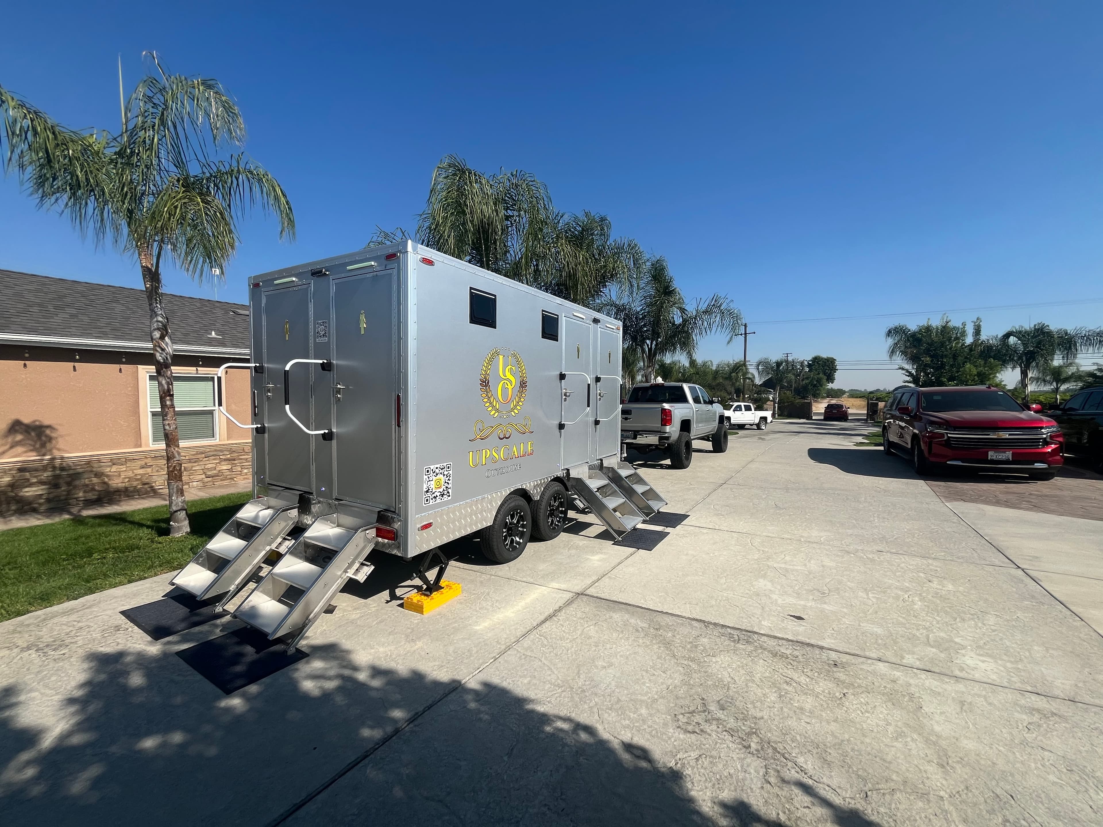 Upscale Outhouse trailer at a residential celebration with palm trees